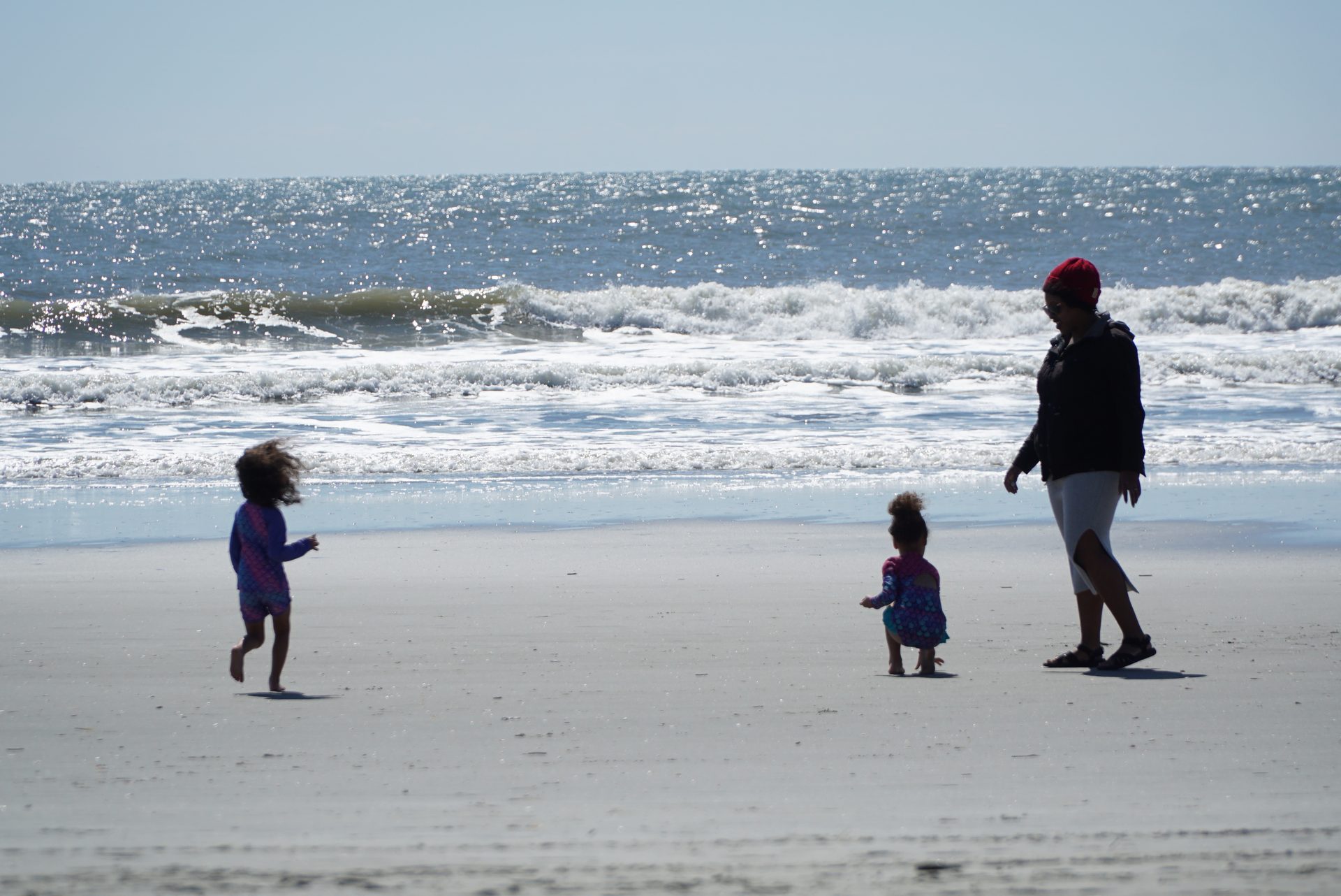 Family walking toward the sparkling Atlantic Ocean at Folly Beach, South Carolina