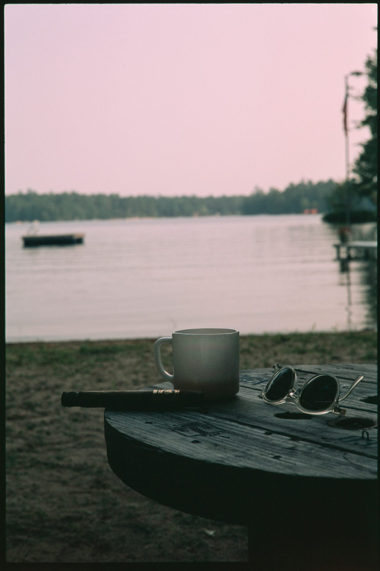 Coffee mug, cigar, and sunglasses on a lakeside table at dusk, Maine — Fuji RDP3