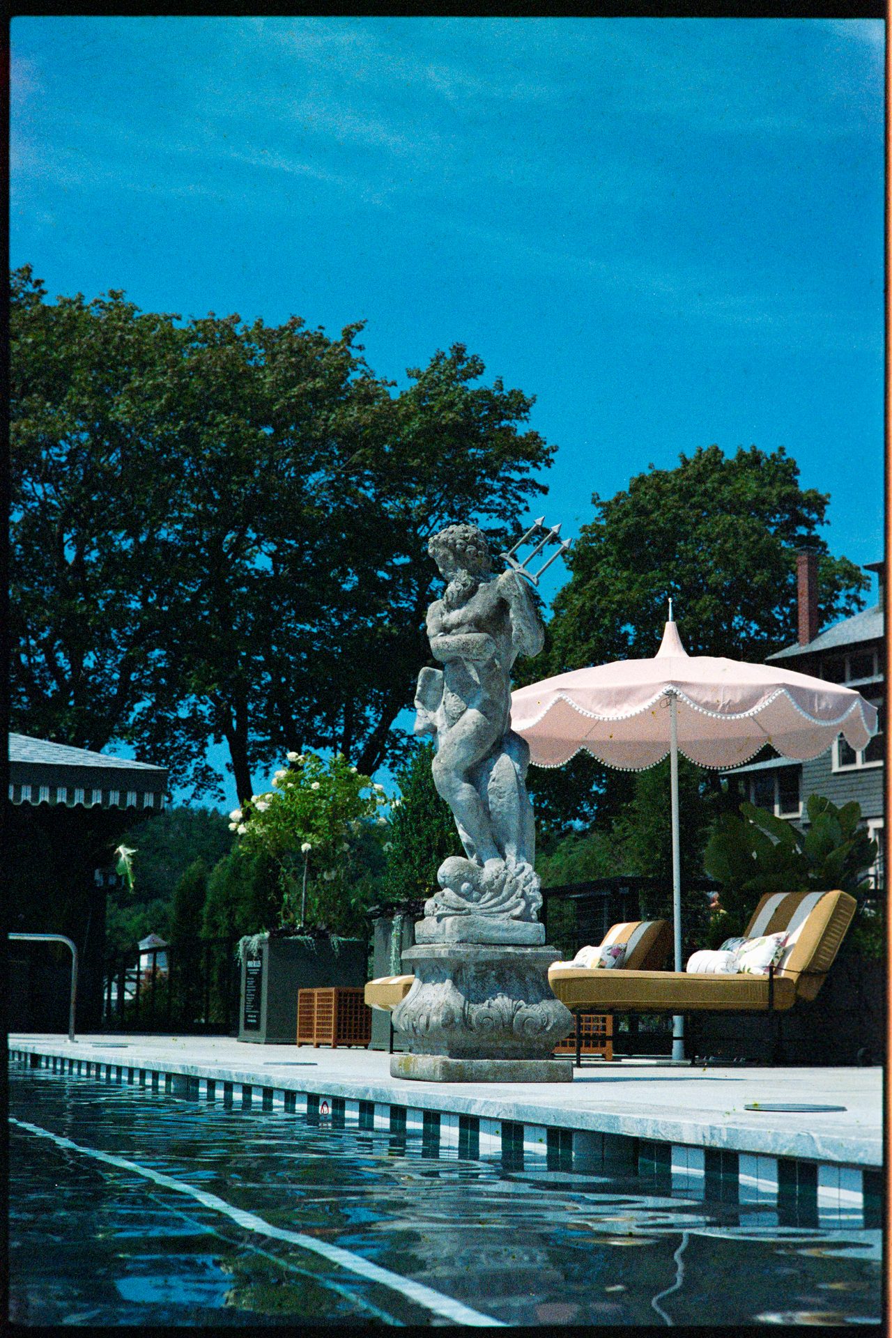 Neptune statue at a Maine hotel pool in summer sun — Kodak Gold 200