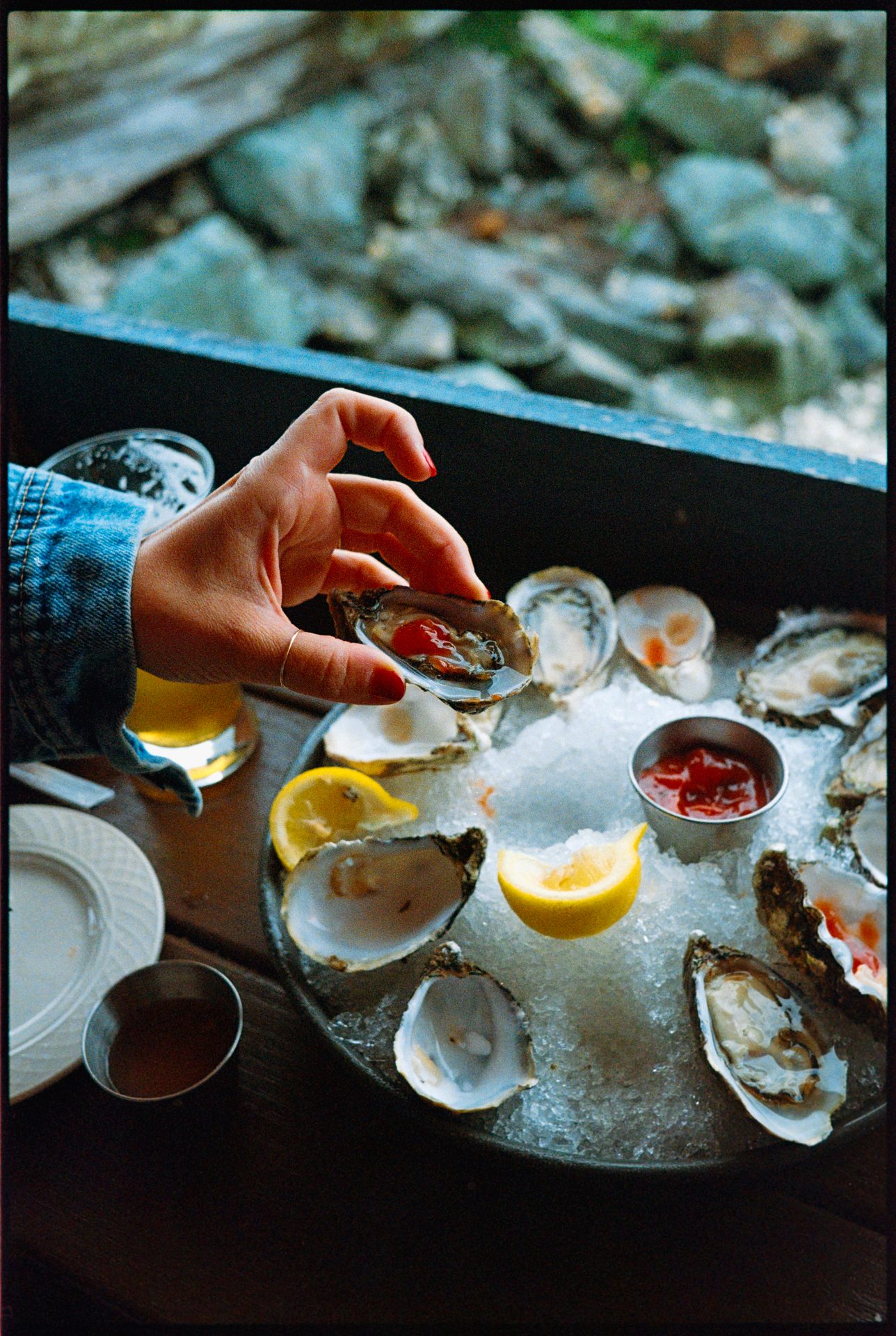 Hand reaching for an oyster on ice at a Whistler restaurant — Kodak Portra 800